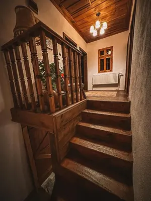 a wooden staircase in a house with a bench at Кътче in Leshten