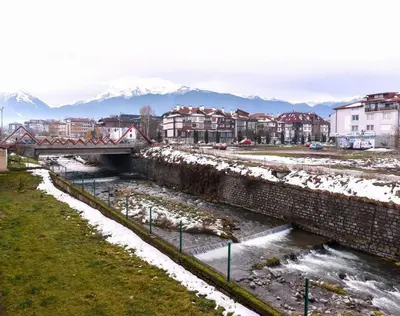a bridge over a river in a city with snow at Bansko Ski & Relax Apartment in Bansko