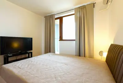 a bedroom with a bed and a flat screen tv at Bansko Ski & Relax Apartment in Bansko