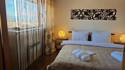 a bedroom with a bed with white sheets and a window at Ioannis Apartment Bansko in Bansko