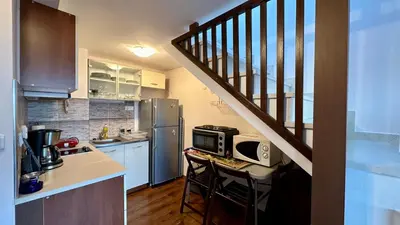 a kitchen with a staircase and a kitchen with a microwave at Ioannis Apartment Bansko in Bansko
