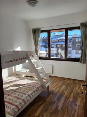 a bunk bed in a room with a large window at KS Rooftop 180° in Bansko
