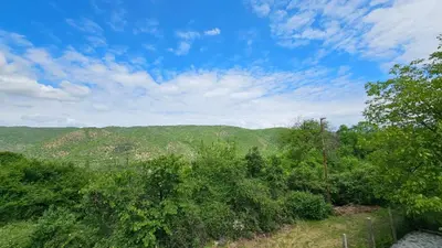 a view of trees and mountains with a blue sky at Вила Доброво in Dobrovo