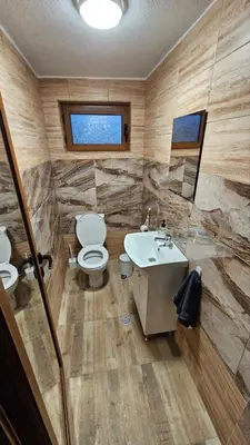 a bathroom with a toilet and a sink at Вила Доброво in Dobrovo