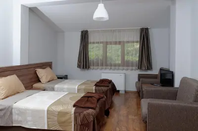 a hotel room with two beds and a couch at Alpine Garden Hotel (Trayanovi Dvori) in Simitli