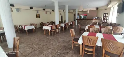 a restaurant with tables and chairs in a room at Alpine Garden Hotel (Trayanovi Dvori) in Simitli