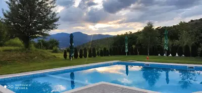 a swimming pool with a view of a mountain at Alpine Garden Hotel (Trayanovi Dvori) in Simitli