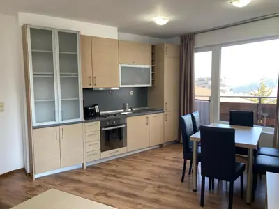 a kitchen and dining room with a table and chairs at Apartment 26А Detelina Residence in Bansko