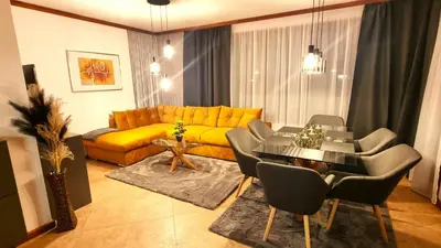 a living room with a yellow couch and a table at Family Luxury Private Apartments in 4 star SPA Resort St Ivan Rilski, Bansko in Bansko