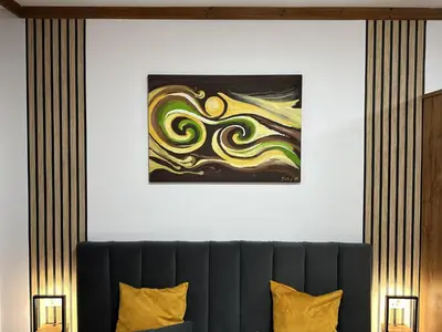 a painting hangs on a wall above a couch at Family Luxury Private Apartments in 4 star SPA Resort St Ivan Rilski, Bansko in Bansko
