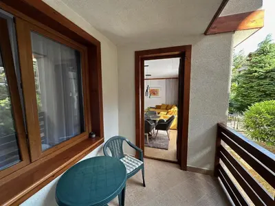 a balcony with a table and a chair and a dining room at Family Luxury Private Apartments in 4 star SPA Resort St Ivan Rilski, Bansko in Bansko