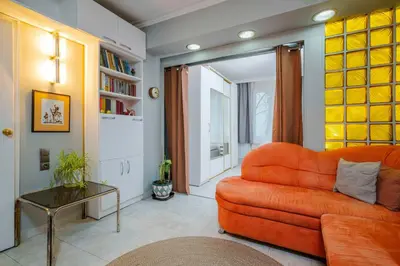 a living room with an orange couch and a table at Cozy Apartment near Vitosha Street by Flat Mаnager in Sofia