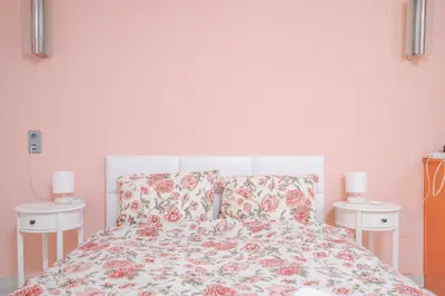 a bedroom with pink walls and a bed with two night stands at Cozy Apartment near Vitosha Street by Flat Mаnager in Sofia