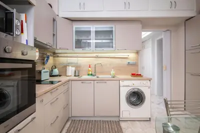 a kitchen with a washing machine and a sink at Cozy Apartment near Vitosha Street by Flat Mаnager in Sofia