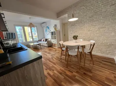 a kitchen and living room with a white table and chairs at Family friendly downtown apart in Sofia