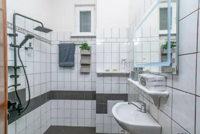 a white tiled bathroom with a sink and a shower at Vintage Home by NDK and Vitosha Blvd with Free Secured Parking in Sofia