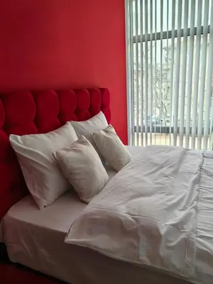 a red bedroom with a white bed with white pillows at 2 Bedrooms apartment. in Plovdiv