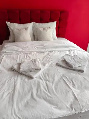 a white bed with white sheets and towels on it at 2 Bedrooms apartment. in Plovdiv