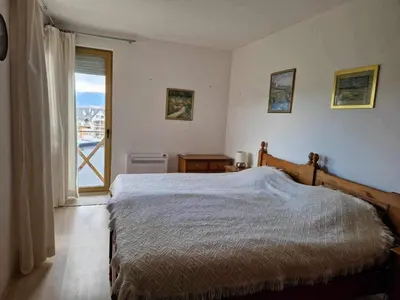 a bedroom with a bed and a large window at Saint John Hill Apartment in Bansko