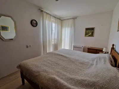 a bedroom with a bed and a mirror and a window at Saint John Hill Apartment in Bansko