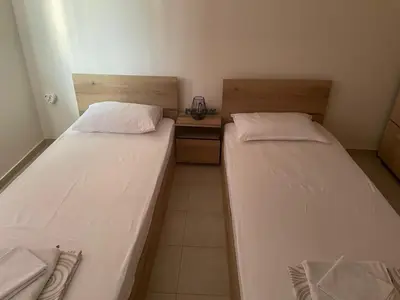 two beds in a small room withermottermott at ЛАЗАРОВИ in Hisarya
