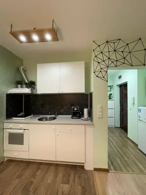 a kitchen with white cabinets and a sink in a room at Sweet Studio Office & Amazing Coffee in Sofia