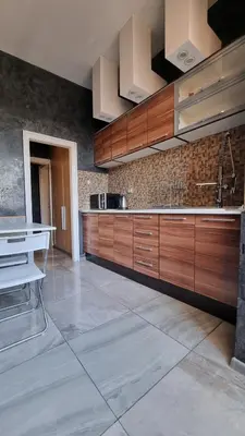 a large kitchen with wooden cabinets and a tile floor at Central Apartment in Sofia