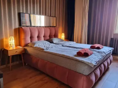a bedroom with a bed with two slippers on it at Central Apartment in Sofia