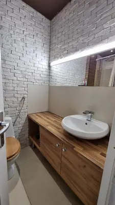 a bathroom with a sink and a white brick wall at Central Apartment in Sofia