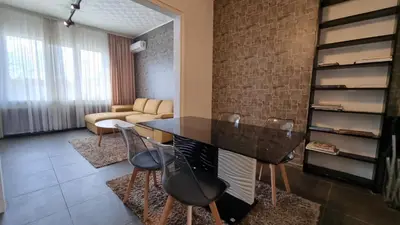 a living room with a table and some chairs at Central Apartment in Sofia