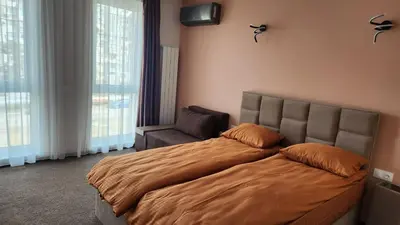 a bedroom with a large bed and a chair at Димоти Апартхотел in Sofia