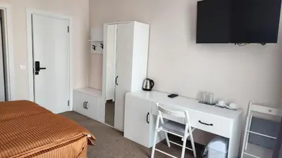a bedroom with a desk with a television on a wall at Димоти Апартхотел in Sofia