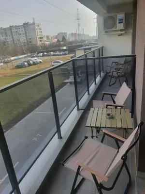 a balcony with chairs and a table and a view at Димоти Апартхотел in Sofia