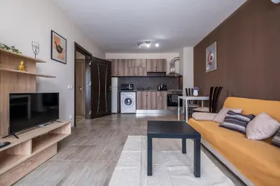 a living room with a yellow couch and a kitchen at Cozy Homes 2 in Sofia