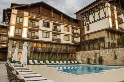 a hotel with a swimming pool in front of a building at Spacious luxury studio with mountain view - SPA available in Bansko