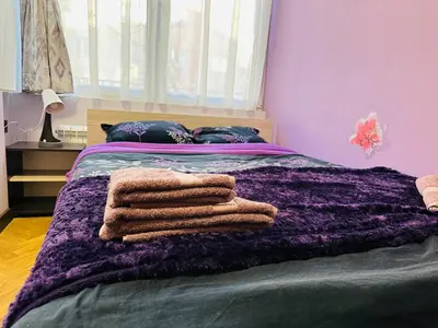 a purple bed with towels on top of it at Luxury Oasis in absolute Center of Sofia in Sofia
