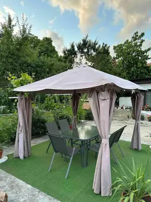 a table and chairs under a large umbrella at Villa Fest in Bansko