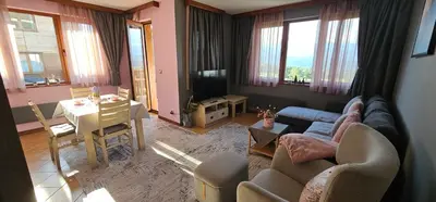 a living room with a couch and a table at Green Peaks Suite in Pirin Golf & County Club in Razlog