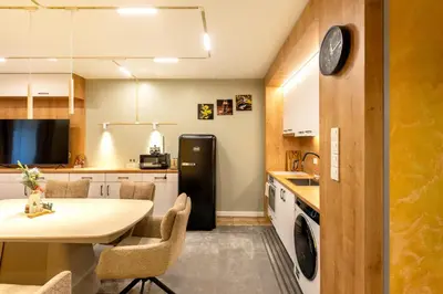 a kitchen with a table and a black refrigerator at Bansko Getaway- Ski & Summer Activities , sleep 6 in Bansko