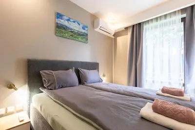 a bedroom with a large bed with a window at Bansko Getaway- Ski & Summer Activities , sleep 6 in Bansko