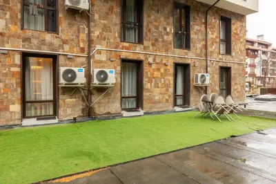 a building with a green lawn in front of a building at Bansko Getaway- Ski & Summer Activities , sleep 6 in Bansko