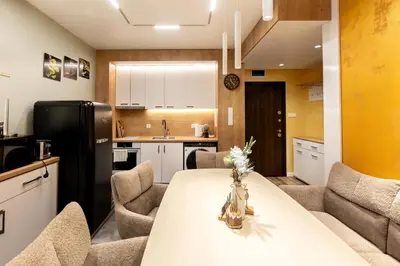 a kitchen with a table and chairs and a refrigerator at Bansko Getaway- Ski & Summer Activities , sleep 6 in Bansko