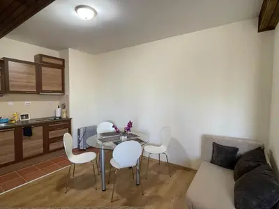 a living room with a table and white chairs at Cozy Mountain Apartment in Borovets