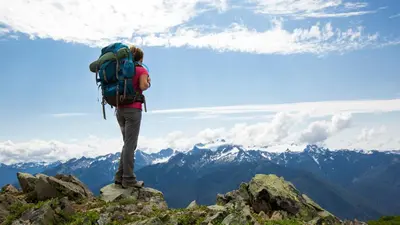 a person with a backpack standing on top of a mountain at Cozy Mountain Apartment in Borovets
