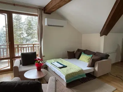 a living room with a couch and a table at Cozy Mountain Apartment in Borovets
