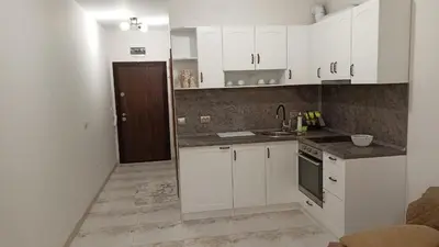 a kitchen with white cabinets and a sink at Апартаменти Мечето in Sandanski