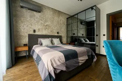 a bedroom with a large bed and a mirror at Luxury 2 Bedroom Apartment - Private Garden in Sofia