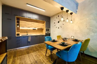 a dining room with a wooden table and blue chairs at Luxury 2 Bedroom Apartment - Private Garden in Sofia