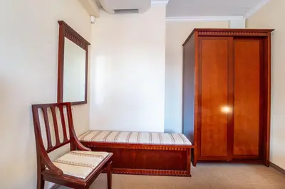 a room with a chair and a mirror and a cabinet at Ski Lift Delight Bansko Apartment in Bansko