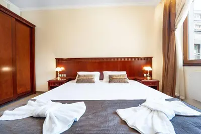 a bedroom with a large bed with white towels on it at Ski Lift Delight Bansko Apartment in Bansko